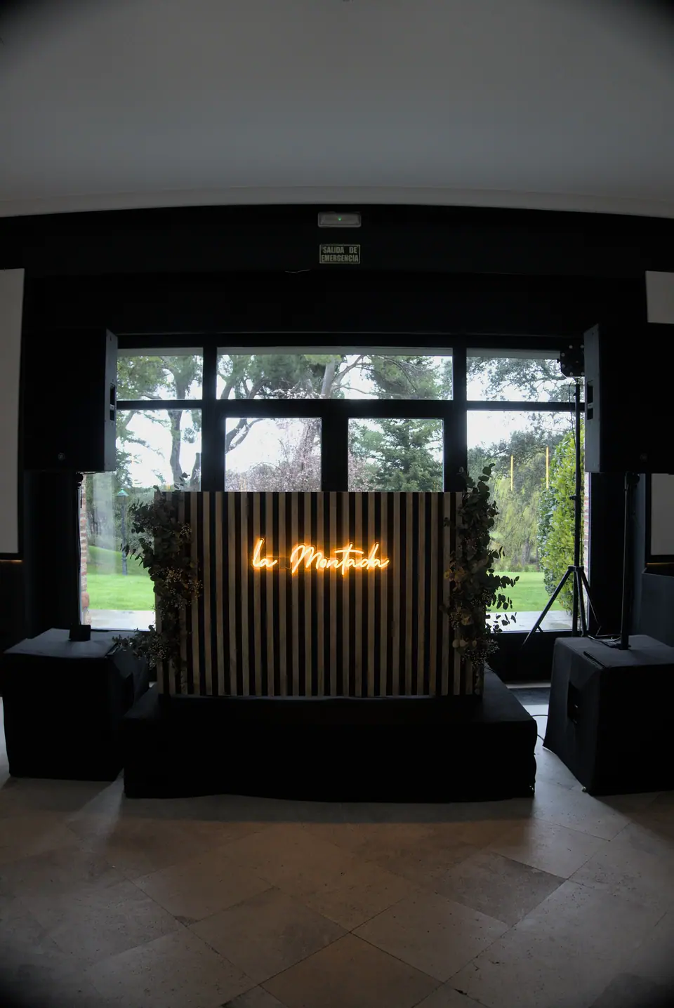 Espacio de evento con letrero de neón de La Montada y arquitectura de arco en ambiente nocturno