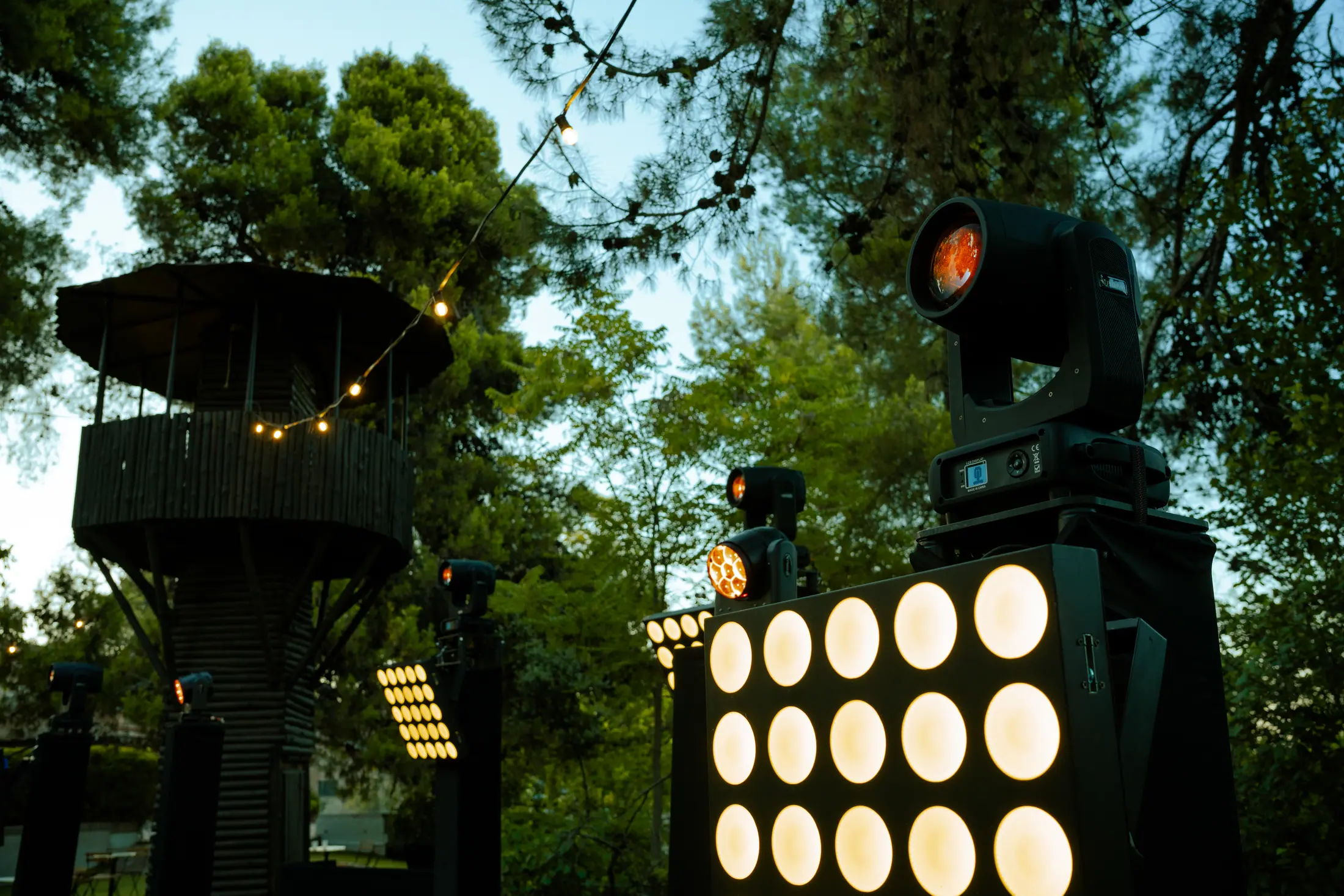 Torre de iluminación LED contra el atardecer, instalación de producción exterior