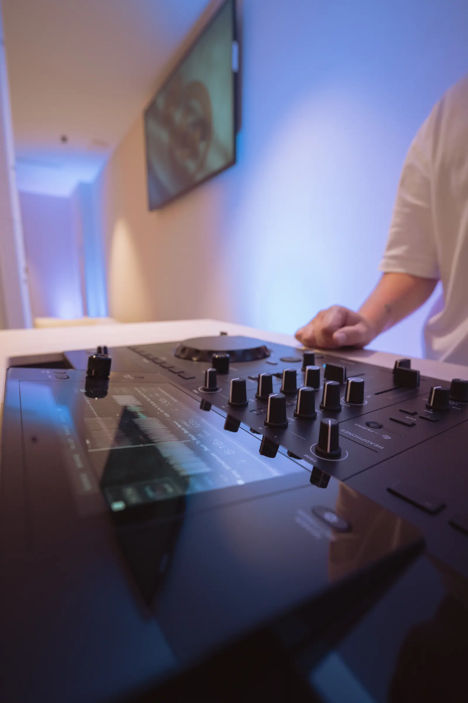 Manos de técnico en consola de DJ durante operación en vivo en evento de sonido e iluminación